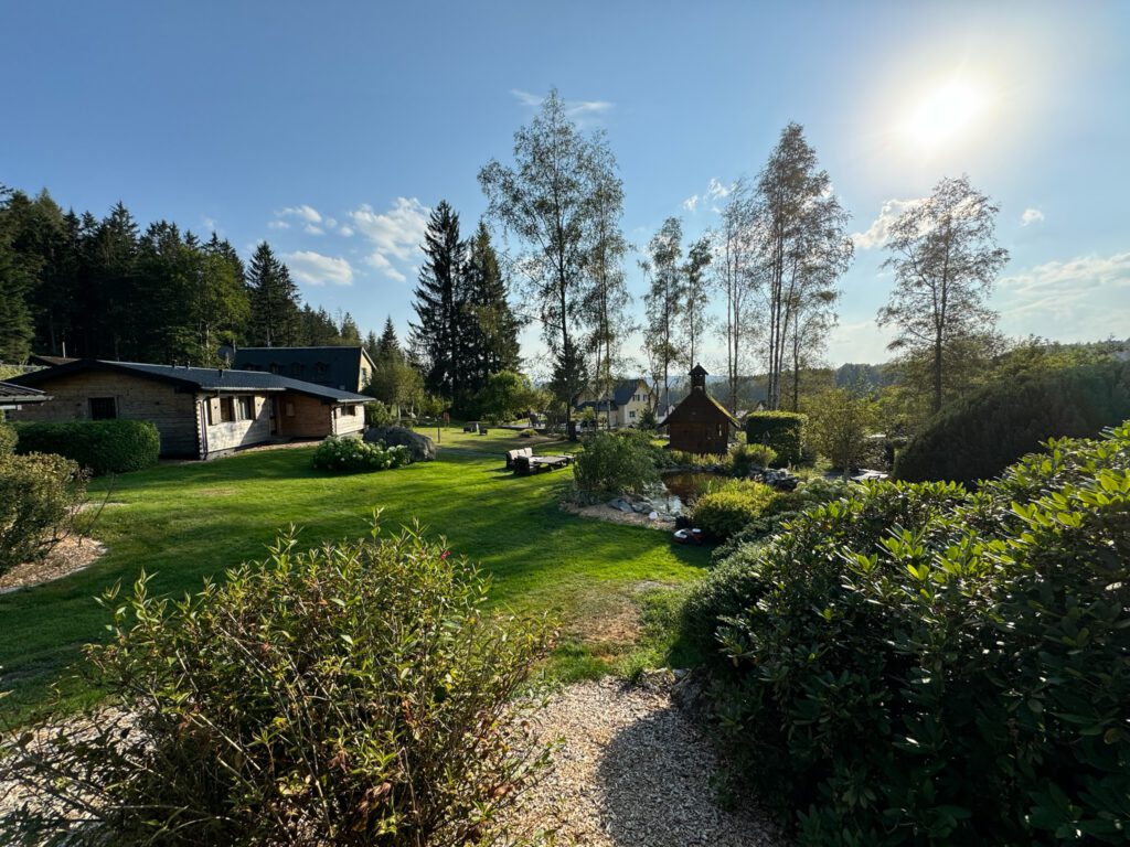 Gepflegte Gartenanlage mit Teich und Hütten im Abendlicht