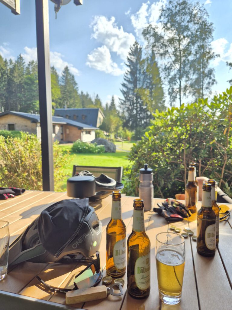Terrassentisch mit Bierflaschen, Fahrradhelm und Werkzeug in der Sonne